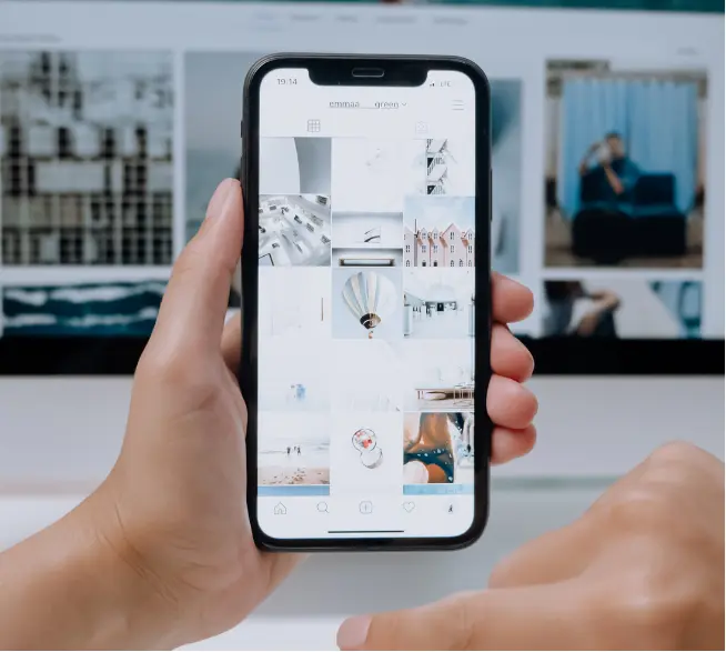 Celular exibindo o feed de uma rede social sobre uma mesa de trabalho